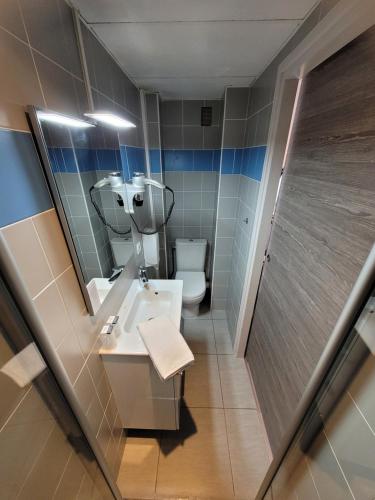 a bathroom with a sink and a toilet and a mirror at Hôtel Aragon - Centre ville gare in Perpignan