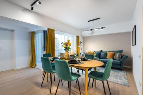 a dining room with a table and green chairs at Spectacular Apartment - 4BR-Terrace - Piata Romana in Bucharest