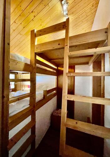 two bunk beds in a room with a wooden ceiling at Club Alpina - Champagny-en-Vanoise in Champagny-en-Vanoise