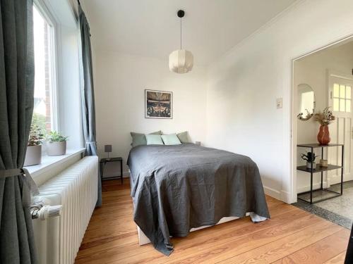 ein weißes Schlafzimmer mit einem Bett und einem Fenster in der Unterkunft Modern und ruhig in Elmshorn in Elmshorn