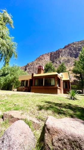 a house with some rocks in front of it at Cabañas Del Sol in Valle Grande