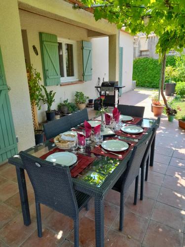 a black table with chairs and plates on it at L'Olivette in Montfrin