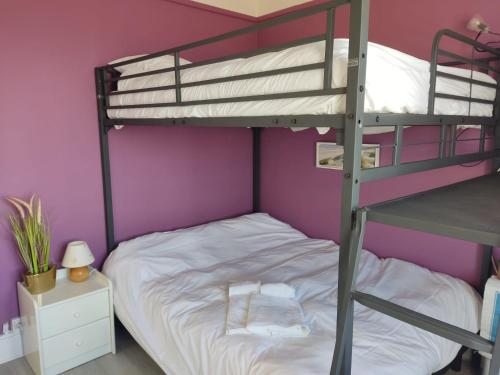 - une chambre avec des lits superposés et un mur violet dans l'établissement Vue imprenable sur la mer depuis notre appartement 