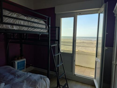 - une chambre avec des lits superposés et une vue sur la plage dans l'établissement Vue imprenable sur la mer depuis notre appartement 