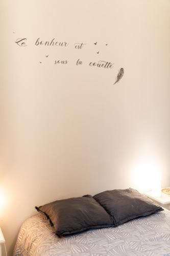 a bedroom with a bed and words on the wall at Aux portes de Lyon Tout confort emplacement idéale Netflix in Givors