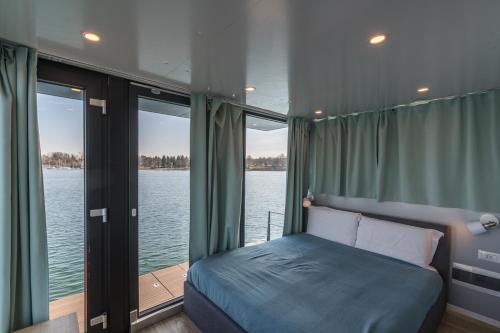 a bedroom with a bed and a view of the water at La Dolce Vita House Boat in Lisanza