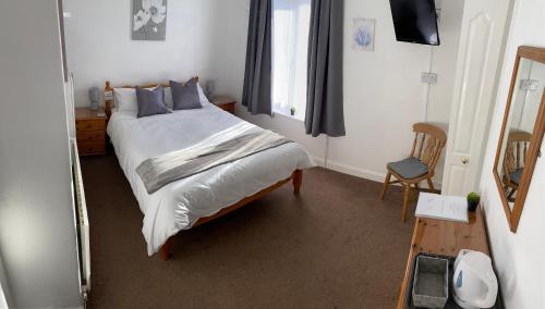 a bedroom with a large bed and a mirror at Stepping Stones in Lincolnshire