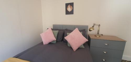 ein Schlafzimmer mit einem Bett mit Kissen und einer Kommode in der Unterkunft Coventry Park House in Parkside