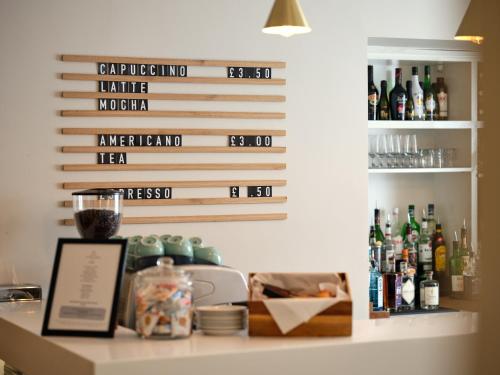 a bar with bottles of alcohol on a wall at Linton Lodge a BW Signature Collection Hotel in Oxford