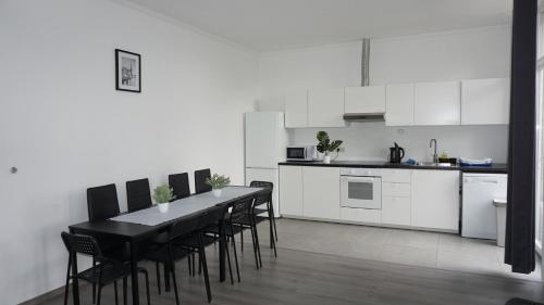 uma cozinha com uma mesa preta e cadeiras num quarto em Apartments Plantin 3 sleeping rooms 2 bathrooms. em Antuérpia