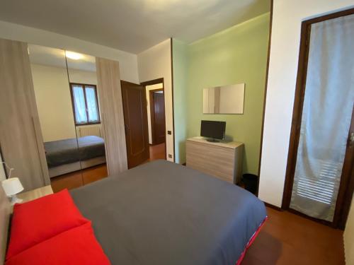 a bedroom with a bed and a television and a window at B&B Segrino in Longone al Segrino