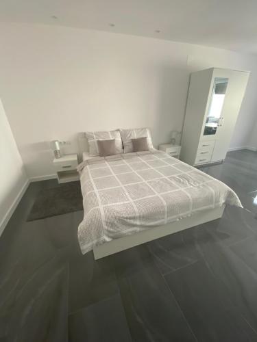 een witte slaapkamer met een bed en een spiegel bij Studio apartman Valentina in Velika Mlaka