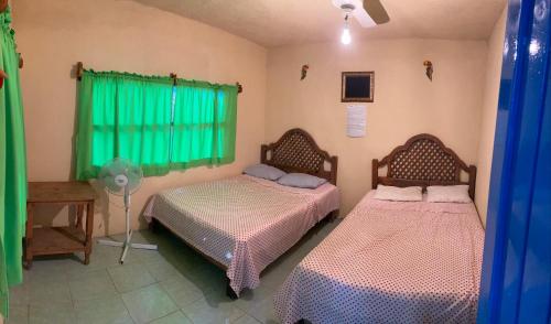 een slaapkamer met 2 bedden en een ventilator bij Hostal Paraíso Teenek Tambaque 