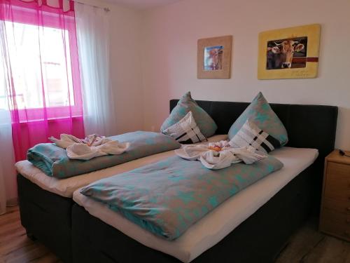 2 Betten mit Handtüchern darüber in einem Zimmer in der Unterkunft Allgäu gemütliche, moderne Wohnung mit Garten-Pool in Argenbühl