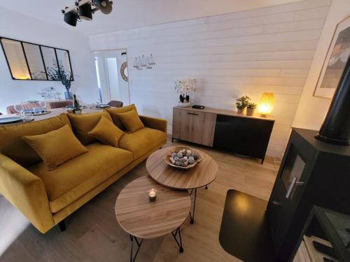 a living room with a yellow couch and a table at Le Cocon - Barneville plage in Barneville-Carteret