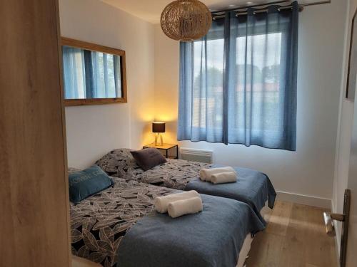 a bedroom with a bed with two pillows on it at Le Cocon - Barneville plage in Barneville-Carteret