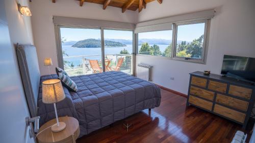 a bedroom with a bed and a large window at Departamento con Vista Panorámica al Lago in San Carlos de Bariloche