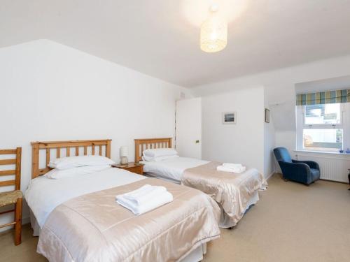 um quarto com 2 camas e uma cadeira azul em Printer`s Place em North Berwick