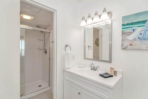 a white bathroom with a sink and a shower at Serenity By The Sea I Crescent Sands I Windy Hill I North Myrtle Beach in Myrtle Beach