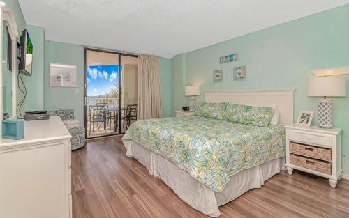 a bedroom with a bed and a balcony at Serenity By The Sea I Crescent Sands I Windy Hill I North Myrtle Beach in Myrtle Beach