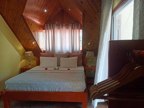 um quarto com uma cama e uma janela em Badamier Self-Catering em La Digue