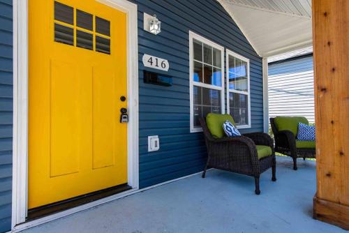 a yellow door on a blue house with chairs at Newly Renovated 3 Bedroom Shelby Park Home **FREE PARKING** in Louisville