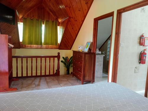 a bedroom with a bed and a wooden ceiling at Badamier Self-Catering in La Digue