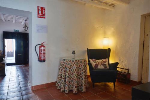 a room with a table and a chair and a lamp at Casa rural La Rosa de Llerena in Llerena