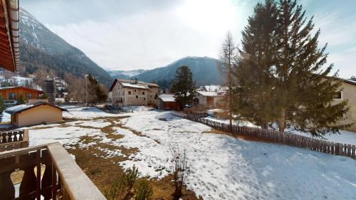 a snow covered village with a mountain in the background at Abitaziun Curtins 1 6 - La Punt Chamues-ch in La Punt-Chamues-ch