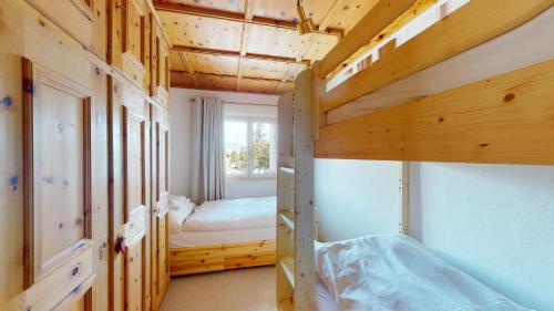a bedroom with two bunk beds and a window at Abitaziun Curtins 1 6 - La Punt Chamues-ch in La Punt-Chamues-ch