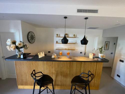 a kitchen with a bar with two stools at Incanto B&B Cefalù in Cefalù