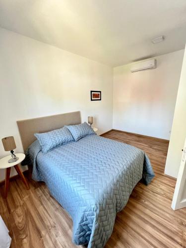 1 dormitorio con 1 cama con edredón azul en COMPLEJO PALERMO SUITES en San Juan