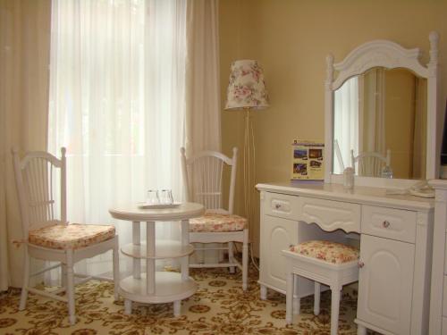 a bathroom with a table and chairs and a mirror at Hotel Saint Petersburg in Karlovy Vary