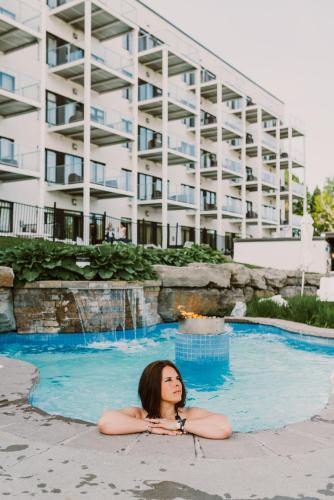 a woman laying in a pool in front of a building at Estérel Resort in Esterel