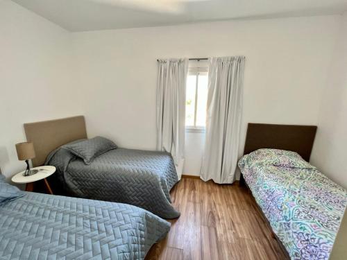 a bedroom with two beds and a window at COMPLEJO PALERMO SUITES in San Juan