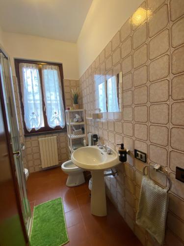 La salle de bains est pourvue d'un lavabo blanc et de toilettes. dans l'établissement B&B Segrino, à Longone al Segrino