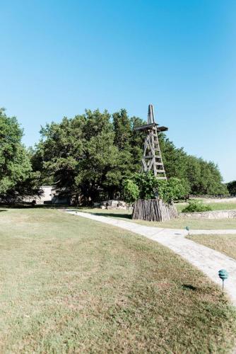 a windmill in the middle of a grass field at Contigo Ranch Fredericksburg in Fredericksburg