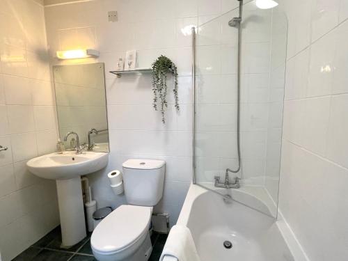a bathroom with a toilet and a sink and a tub at Sea View Family Stay by Beach Gym & Parking in Bournemouth