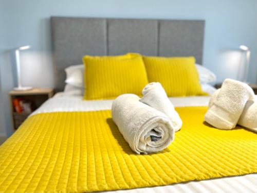 a bed with two rolls of towels on it at Sea View Family Stay by Beach Gym & Parking in Bournemouth