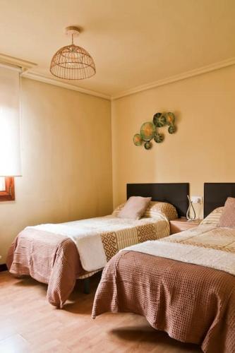 a bedroom with two beds and a chandelier at Urbión Etxea in Viana