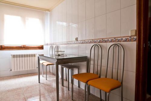 a kitchen with a table and some chairs and a window at Urbión Etxea in Viana