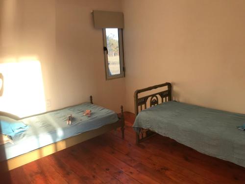 1 dormitorio con 2 camas y ventana en Chacra marítima en Garzon Jose ignacio, en José Ignacio