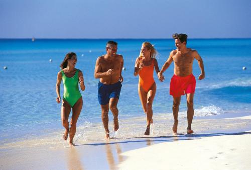 a group of people running on the beach at Riu Palace Mexico - Adults Only - All Inclusive in Playa del Carmen