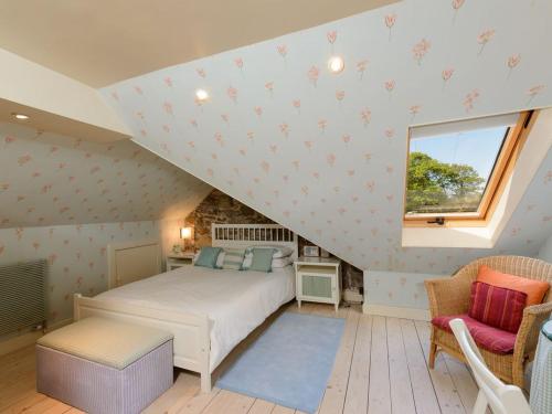 a bedroom with a white bed and a window at Nungate in North Berwick