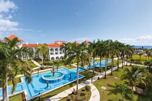 an aerial view of a resort with a pool and palm trees at Riu Palace Mexico - All Inclusive in Playa del Carmen