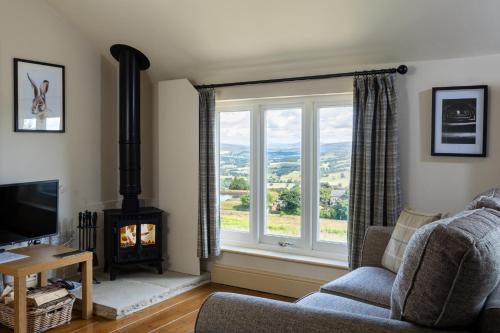 a living room with a fireplace and a window at Silver Well Cottage in Ilkley
