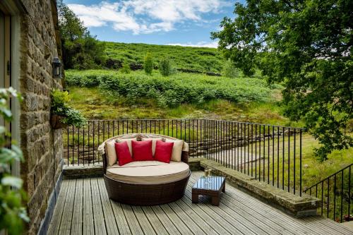 a chair sitting on a wooden deck with a fence at Silver Well Cottage in Ilkley