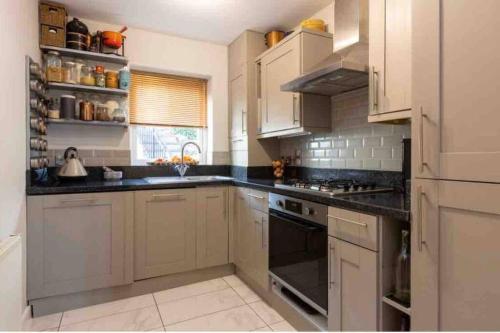 a kitchen with white cabinets and black counter tops at Pittman Apartment A Luxury Sea View Apartment in Torquay