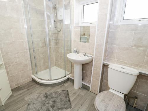 a bathroom with a shower and a toilet and a sink at 17 Ffordd Gwenllian in Llanfairpwllgwyngyll