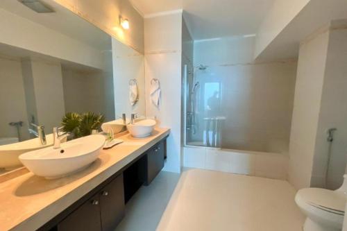 a large bathroom with two sinks and a shower at Apartamento Amoblado en Cinta costera Panama largas estadias in Panama City